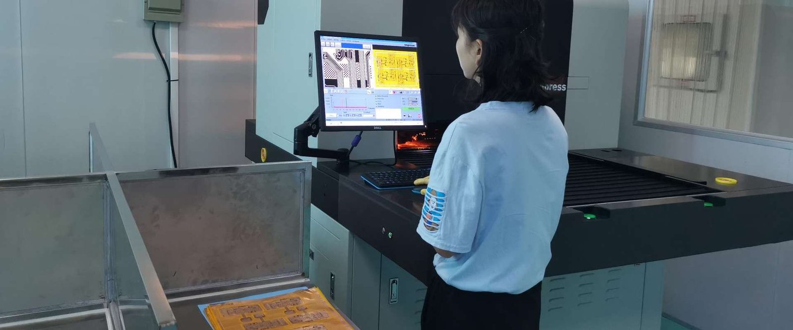 Bare-board inspection workstation | GlobalWellPCB Operator reviewing a bare circuit board at an inspection workstation