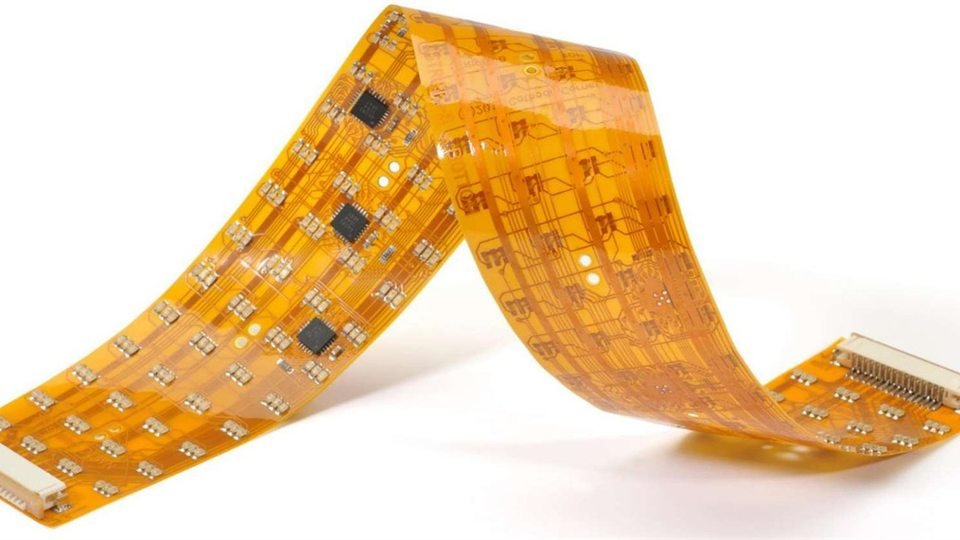 Bent flexible circuit | GlobalWellPCB Amber flexible circuit folded into a bend with visible traces and components