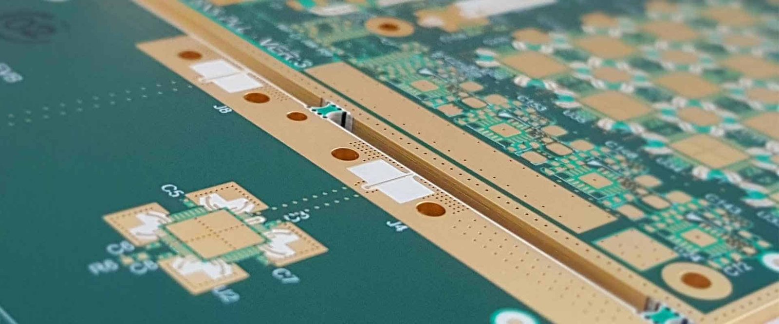 Close-up of a green circuit-board edge with copper pads and routed traces