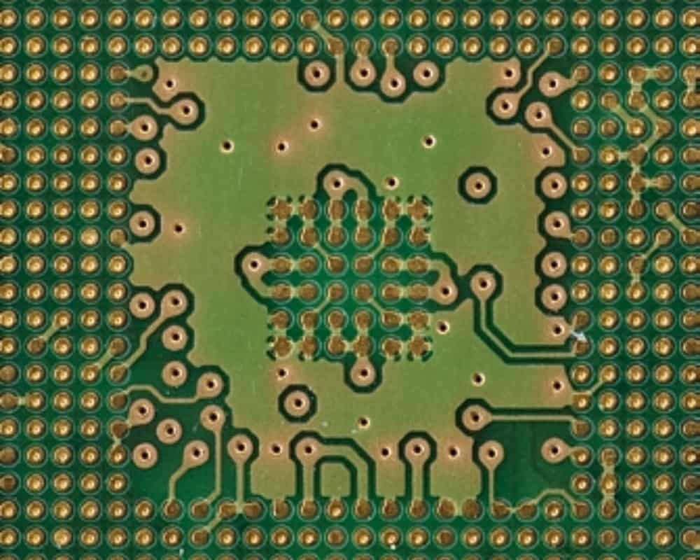 Small via and trace array | GlobalWellPCB Close-up of small circuit-board via openings connected by fine copper traces