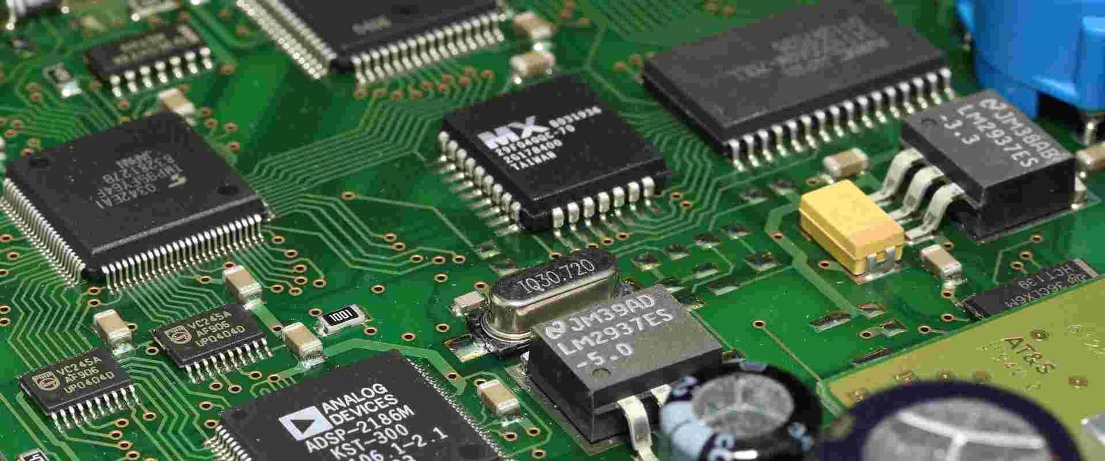 Electronic component board close-up | GlobalWellPCB Close-up of integrated circuits, connectors and small components on a green assembly