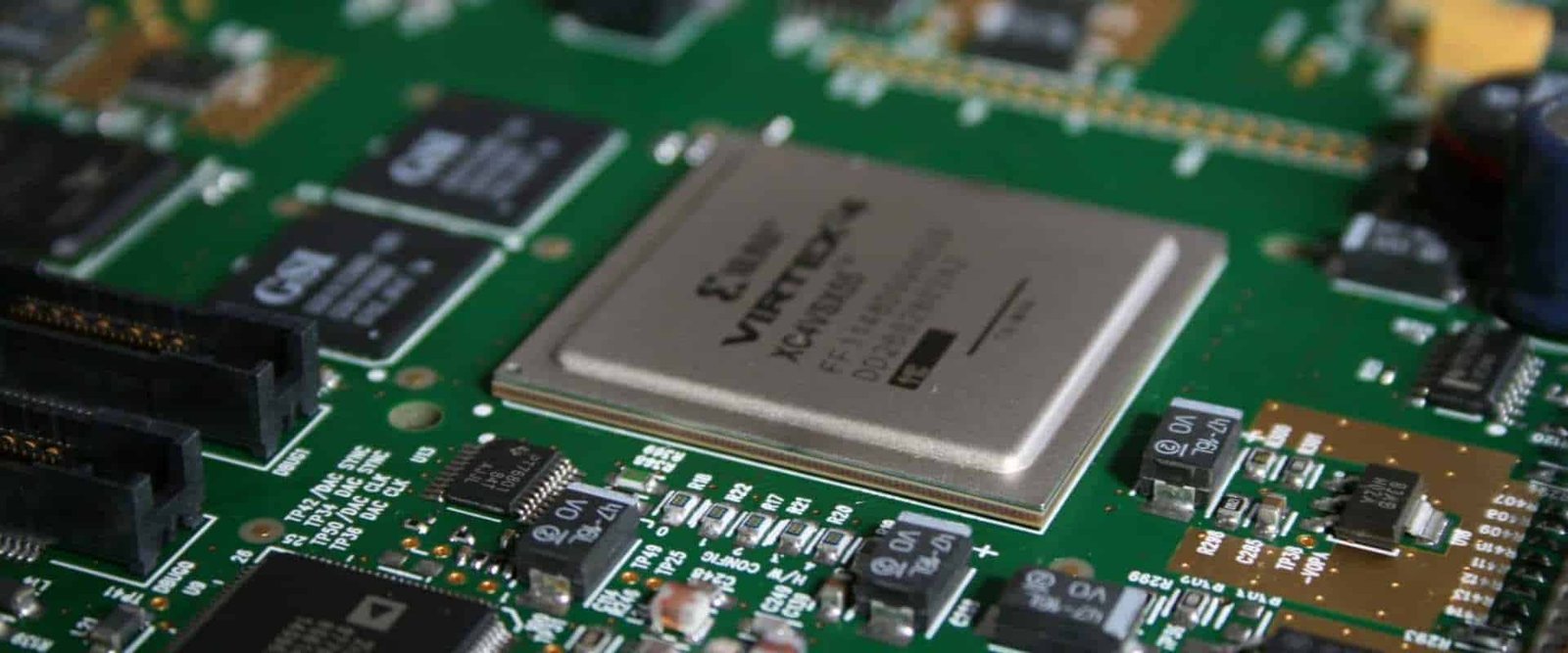 Large integrated-circuit package surrounded by smaller components on a green board
