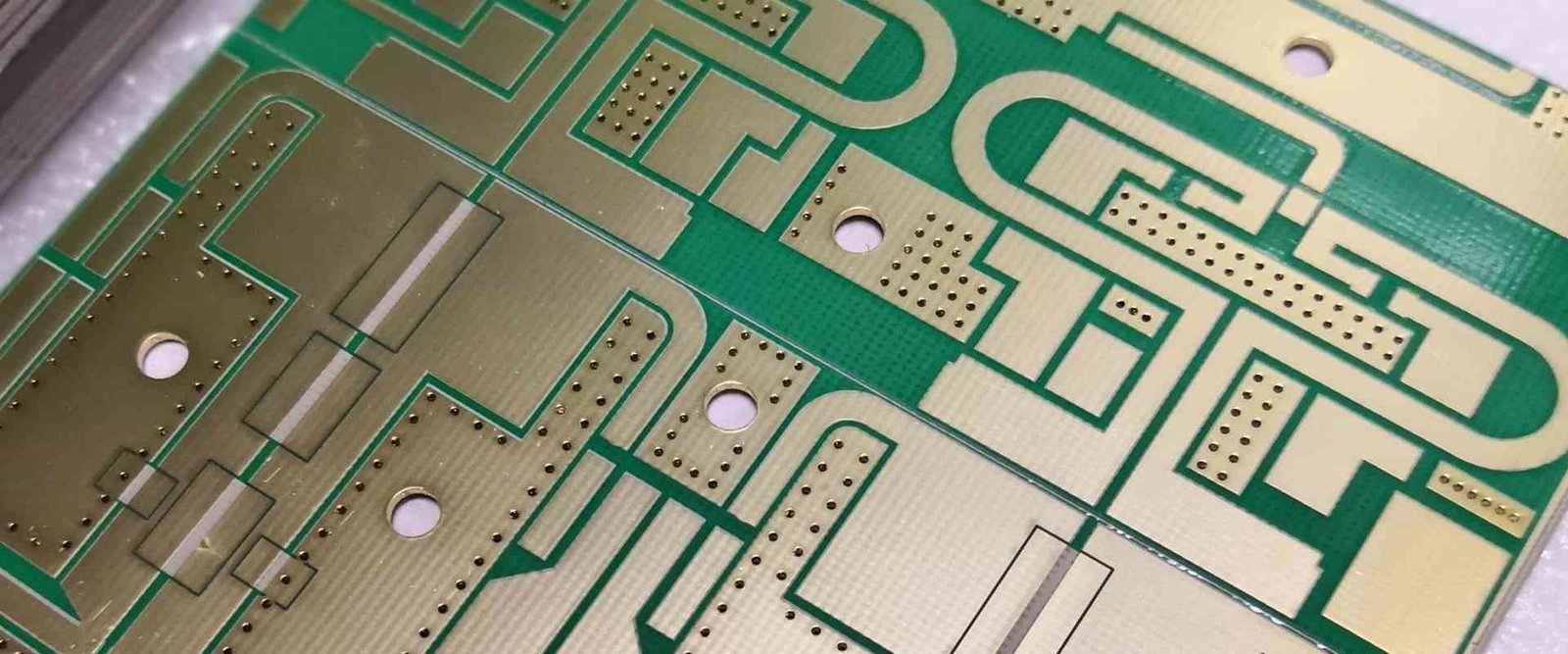 RF copper trace detail | GlobalWellPCB Close-up of exposed copper traces, ground areas and mounting holes on a circuit substrate