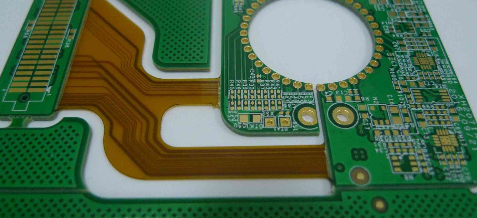 Rigid-flex transition detail | GlobalWellPCB Close-up of the transition from a green rigid board to amber flexible traces