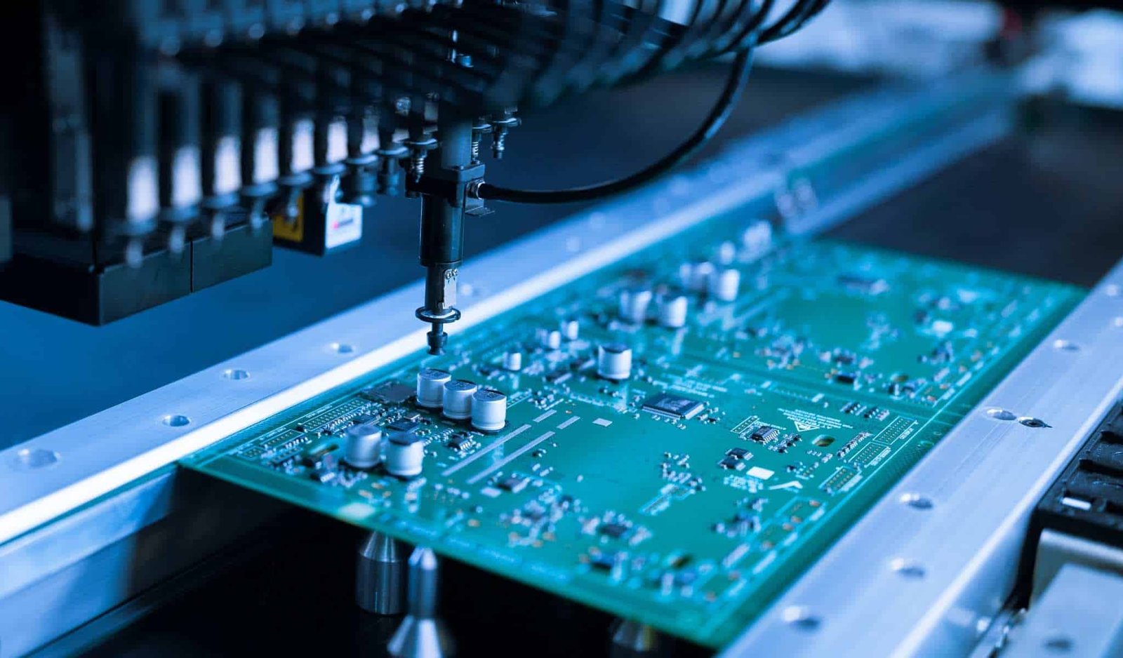 SMT placement machine example | GlobalWellPCB Surface-mount placement heads positioned above a populated circuit board