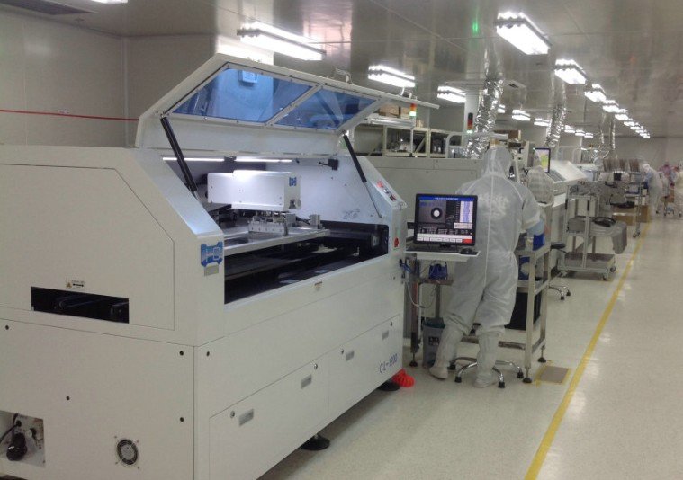 Solder Paste Printing Machine | GlobalWellPCB Solder paste printing machine with an open enclosure, control display and operator on an assembly line
